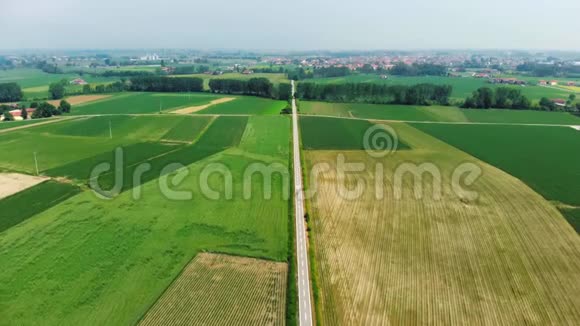 空中飞行飞过自行车道穿过乡村人们沿着自行车道骑自行车穿过耕地和农田视频的预览图