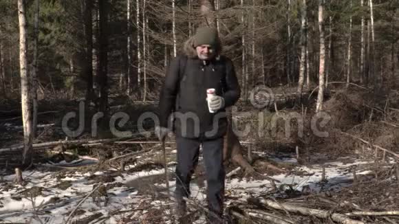 森林里有弯刀和热水瓶的徒步旅行者视频的预览图