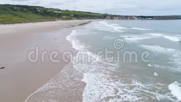 北爱尔兰白朴湾安特里姆孩子们在海滩上玩耍无人机飞过镜头4k视频的预览图