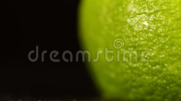 石灰壳靠近黑色背景带有水滴的柠檬宏观射击柑橘树上的水滴视频的预览图
