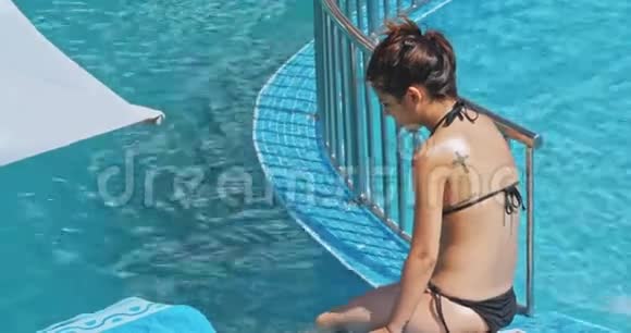 性感的年轻女子在游泳池附近放松视频的预览图
