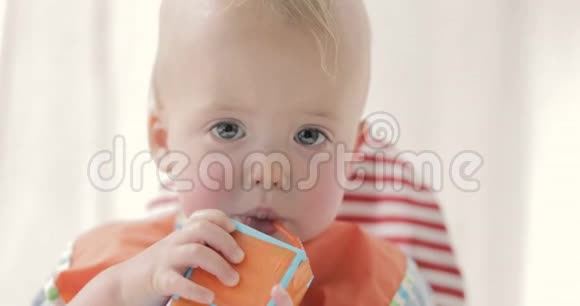 可爱的男孩喝果汁或牛奶从一包视频的预览图