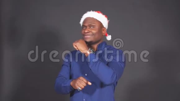 非洲男子在圣诞老人的帽子里跳舞慢动作的肖像视频的预览图