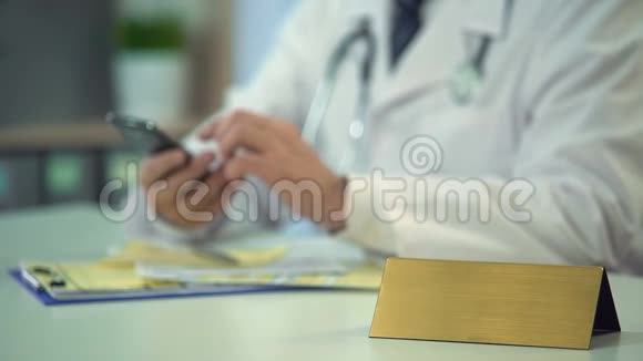 智能手机上统一发短信病人的医生桌子上空白铭牌视频的预览图