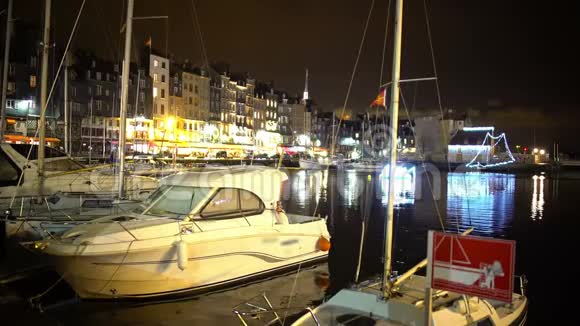 夜晚停泊在城市港口的游艇和船只照亮了堤岸视频的预览图