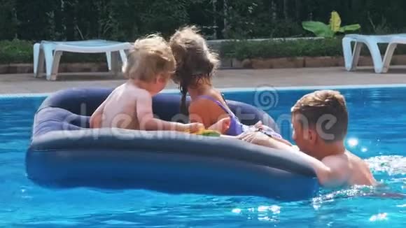 微笑快乐的孩子们在游泳池里的一个漂浮物上视频的预览图