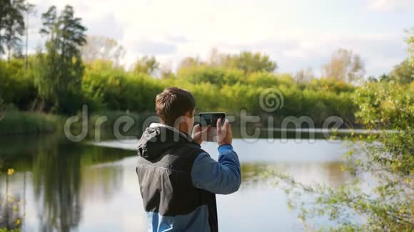 年轻人在电话里拍秋景的照片视频的预览图