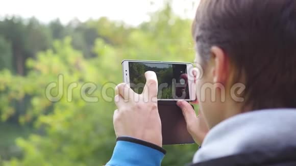 年轻人在电话里拍秋景的照片视频的预览图