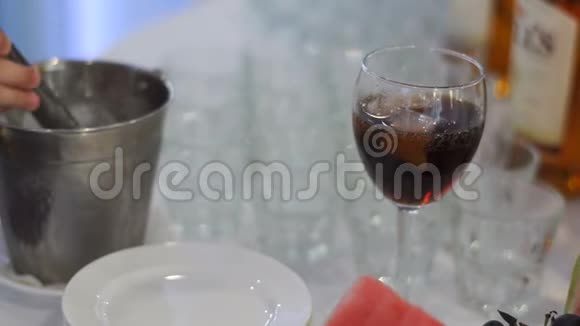 女服务员的男手正把冰块和饮料放进玻璃杯里结婚典礼视频的预览图