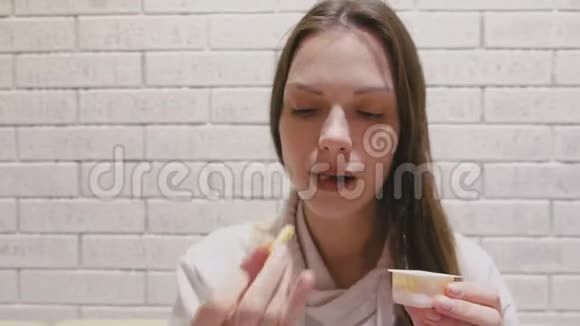 女人在咖啡馆里吃薯条和奶酪酱视频的预览图