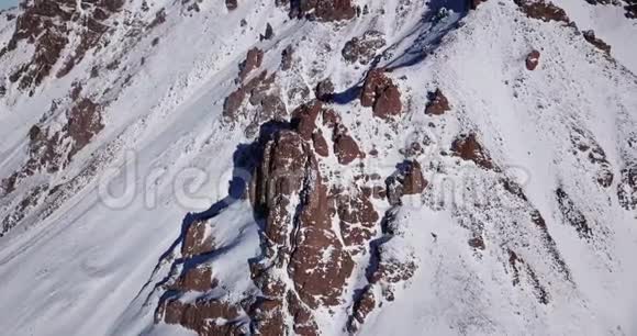 史诗在覆盖着雪的无人机岩石上飞翔陡峭的岩石在山间的雪间视频的预览图