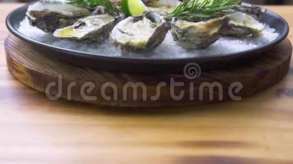 牡蛎用奶酪和草药在木制背景的盘子里烤海鲜背景文案空间地中海风味视频的预览图