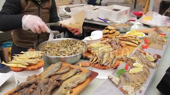 街头卖菜的把脆咸的凤尾鱼打包开胃小吃视频的预览图