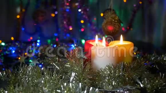新年蜡烛特写和圣诞装饰品有彩色灯光的模糊背景照相机的移动视频的预览图