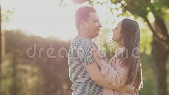 一对浪漫的情侣在绿色的夏天公园里他们彼此很亲近他们在阳光下互相看着视频的预览图