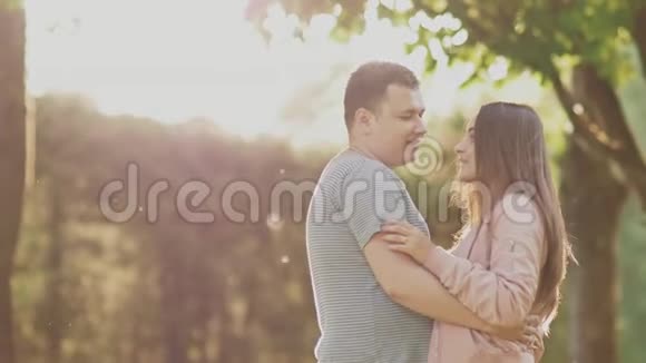 一对浪漫的情侣在绿色的夏天公园里他们彼此很亲近他们在阳光下互相看着视频的预览图