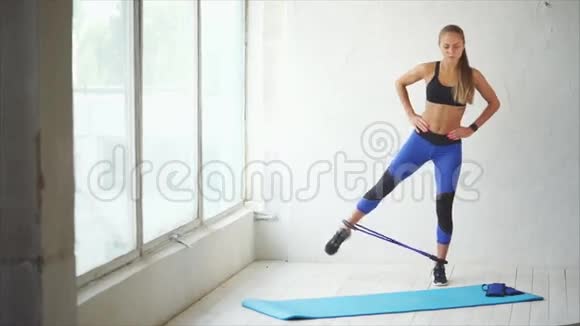 健身教练使用运动工具伸展腿部外侧肌肉视频的预览图