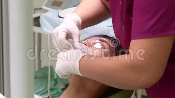 牙医的助手把旋转器插入病人的口腔视频的预览图