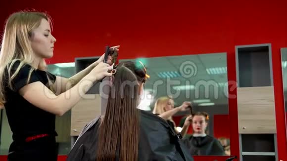 女理发师扎客户头发制作时尚发型的过程视频的预览图