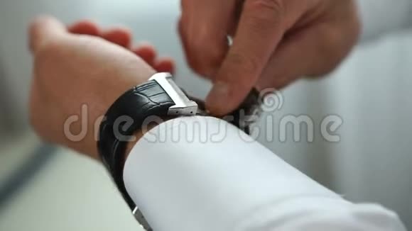 近景的时尚男子把豪华的银手表放在他的手上视频的预览图
