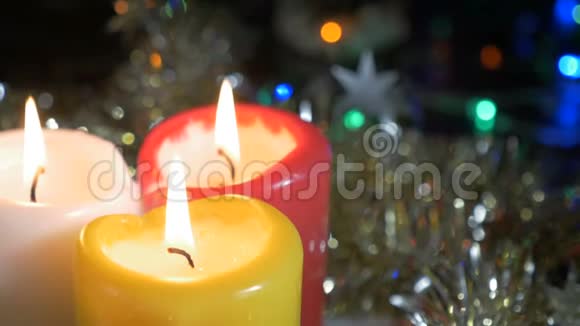 新年蜡烛特写和圣诞装饰品有彩色灯光的模糊背景视频的预览图