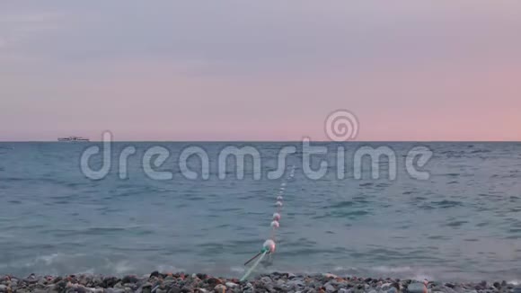 夏天晚上在海边小波浪在灰色的卵石上冲浪视频的预览图