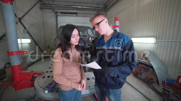 机械师在修理厂向客户展示汽车的问题视频的预览图