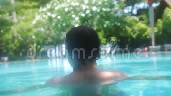 年轻人在热带度假胜地的游泳池里跳跃和游泳慢动作3840x2160视频的预览图
