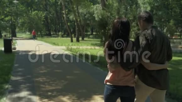 在公园散步的情侣的后景视频的预览图