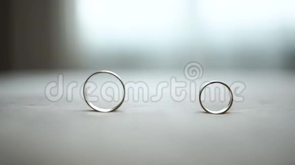 桌子上两个结婚银戒指的组成雄环正在滚动到另一个视频的预览图