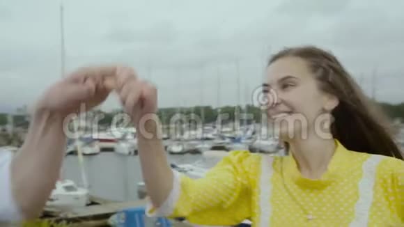 欢快的女孩和男孩在码头上跳起华尔兹舞背景是游艇视频的预览图