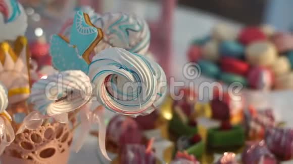 在婚礼上用不同颜色的饼干糖果和蛋糕覆盖的糖果吧在甜品摊的移动摄像头视频的预览图
