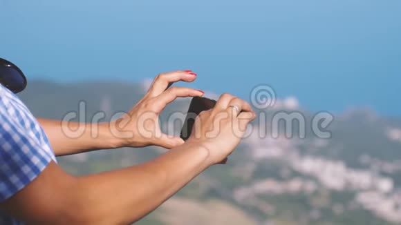 女游客在电话中拍照一幅美丽的蓝色大海和山脉的景色快关门慢慢慢慢视频的预览图
