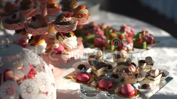 婚礼糖果接待充满了不同的彩色蛋糕和饼干装饰的水果和马卡龙视频的预览图