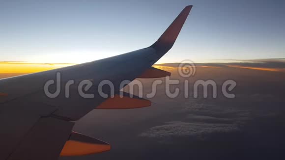 日落时飞机在天空中高高飞起从侧面窗口查看视频的预览图