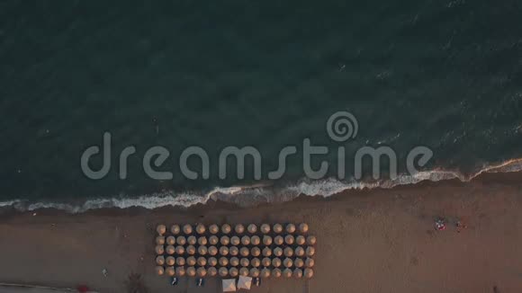 在海滩的伞下拍摄蓝色的大海和日光浴视频的预览图