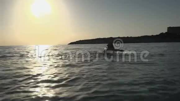 幸福的女人在日落时分从海洋中浮出水面视频的预览图