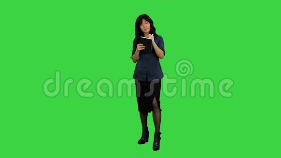 年轻的亚洲女商人在绿色屏幕的采访中做笔记Chroma键视频的预览图