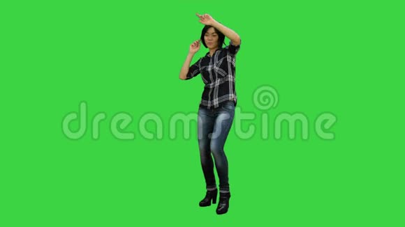 快乐的女孩在绿色屏幕上跳舞和听音乐Chroma键视频的预览图