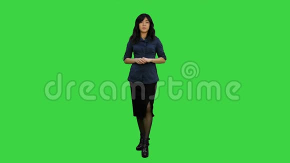 年轻迷人的亚洲女性对着镜头说话在绿色屏幕上呈现一些东西Chroma键视频的预览图