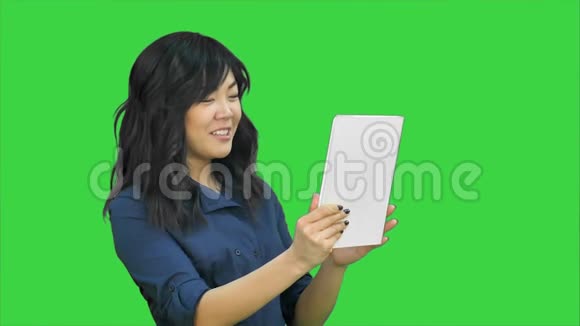 亚洲商务小姐用平板电脑在绿色屏幕上聊天Chroma键视频的预览图