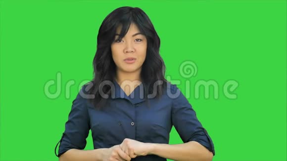 美丽的亚洲年轻女子在绿色屏幕上做演讲Chroma键视频的预览图