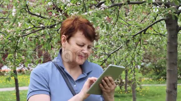 老年妇女在户外浏览触摸板视频的预览图