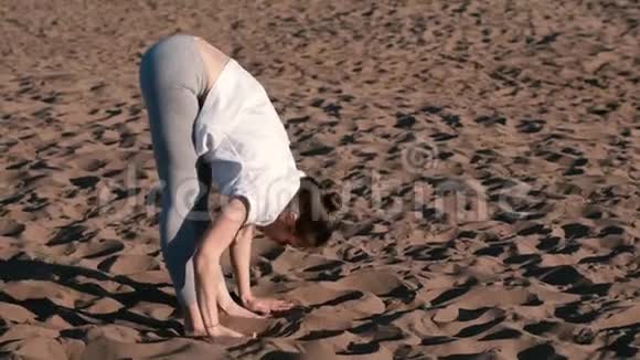 女人在城市河边的海滩上伸展瑜伽美丽的景色文尼亚萨视频的预览图