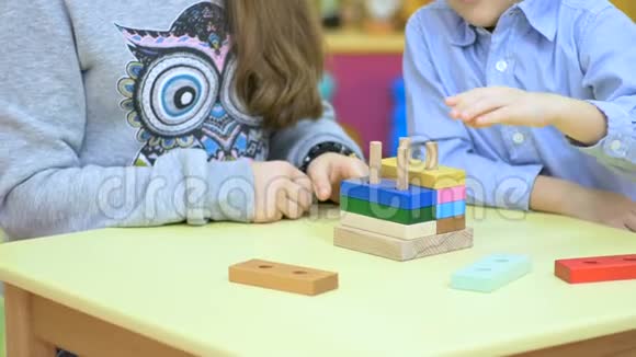 可爱的孩子在桌子上玩木玩具视频的预览图