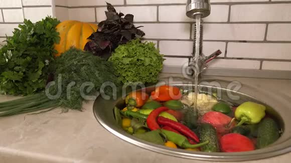 新鲜蔬菜和水果在水槽里的流水下西红柿和黄瓜胡椒和大视频的预览图