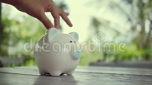 把硬币扔进储蓄罐为将来存钱视频的预览图