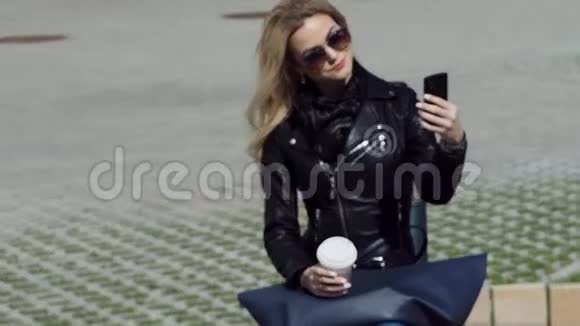 穿皮夹克的时髦女孩在智能手机上自拍视频的预览图