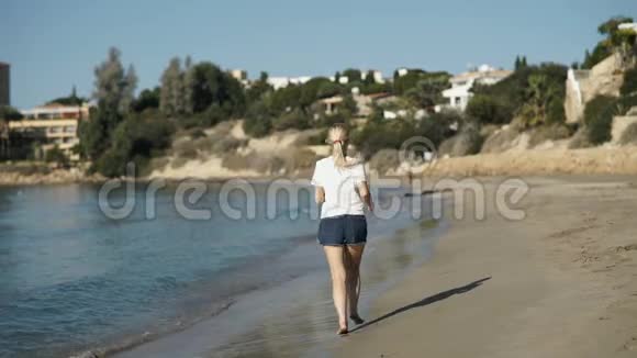 年轻女子听音乐沿着海边奔跑视频的预览图