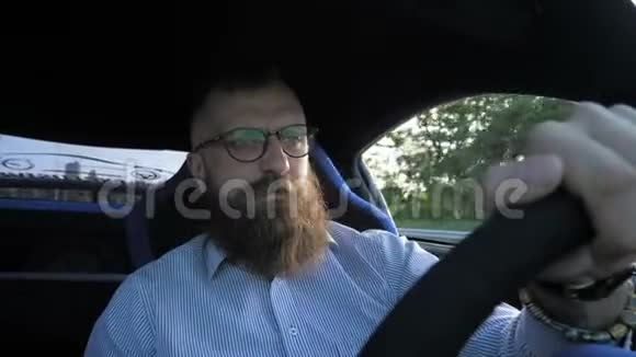 戴眼镜的严肃的小胡子男子坐在方向盘后驾驶跑车视频的预览图